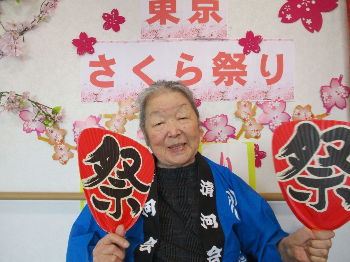さくら祭りの飾りの前で