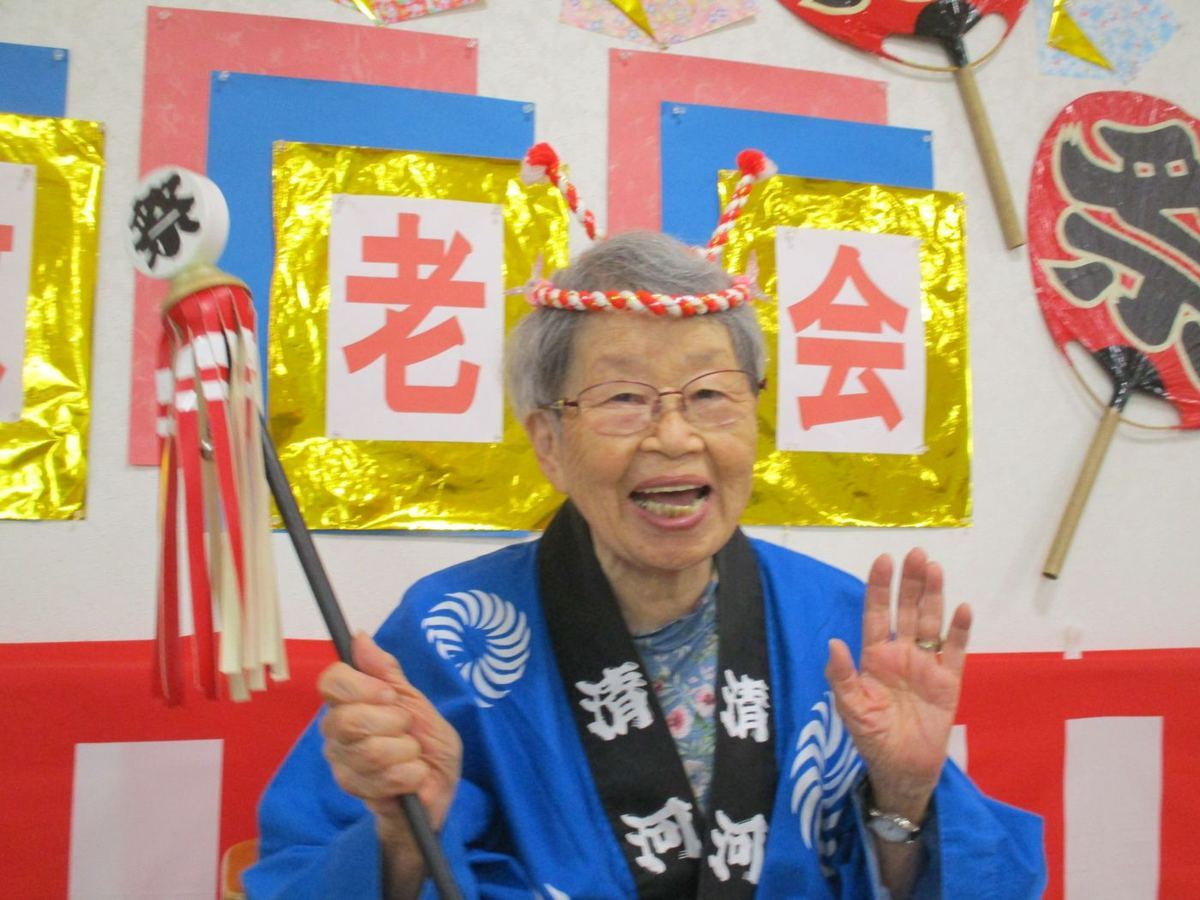 敬老会の飾りの前で