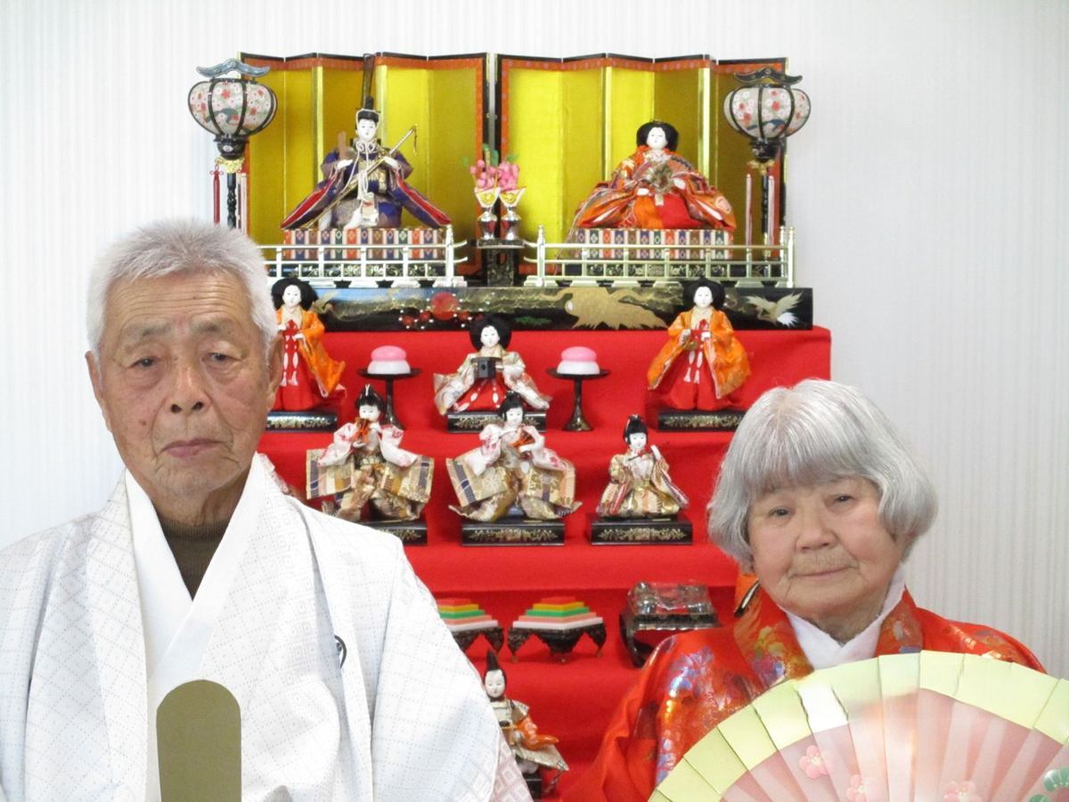 ひな人形の前でお内裏様とお雛様の衣装